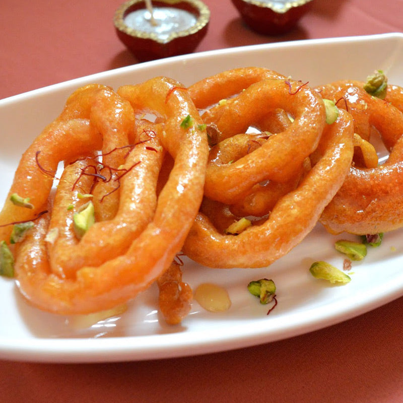 Golden crispy jilebi sweet soaked in sugar syrup, a traditional Indian dessert enjoyed during festivals and celebrations.