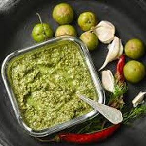 Fresh Amla Thokku (Gooseberry Relish) in a glass bowl with garlic and red chilies.