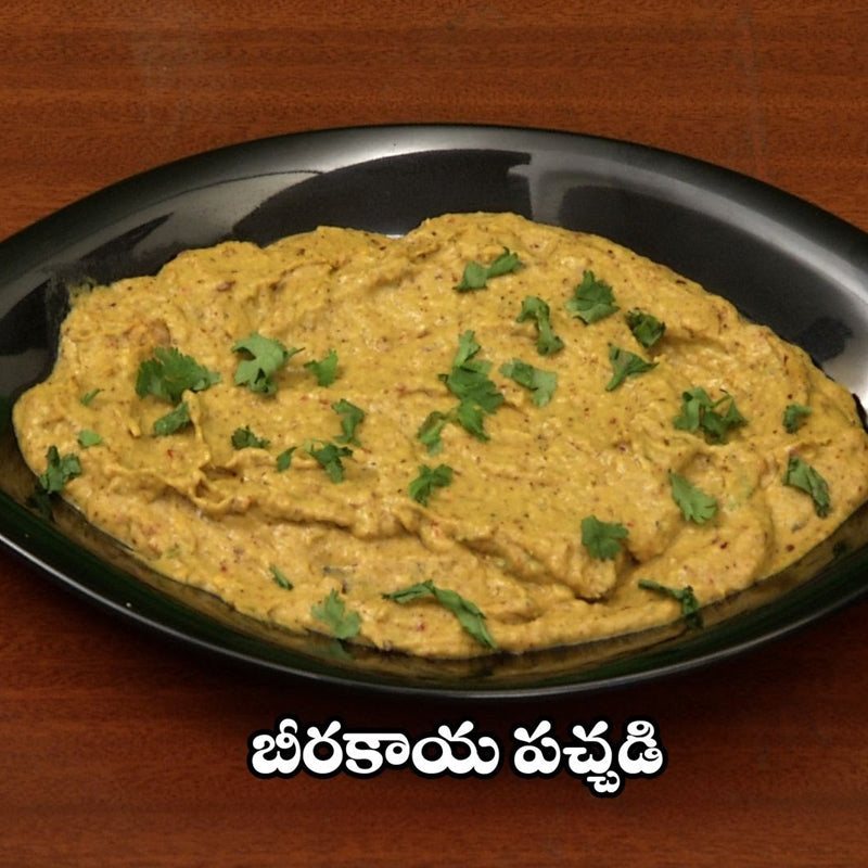 Fresh Birakaya Roti Pachadi (Ridge Gourd Chutney) garnished with cilantro on a black serving plate.