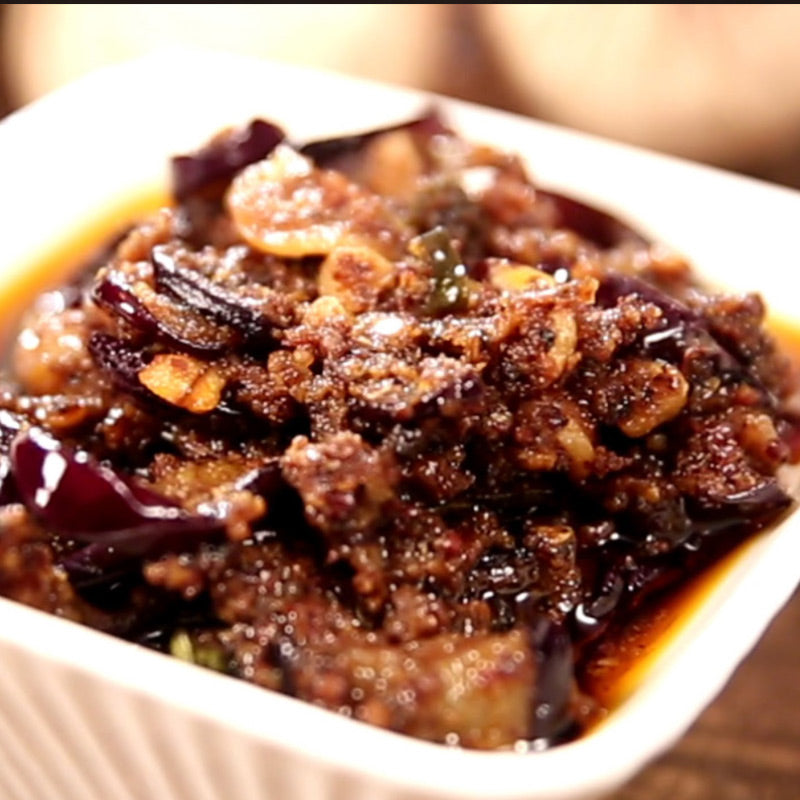 Spicy brinjal pickle served in a bowl with visible eggplant pieces and thick masala by Athithi Gruha Foods