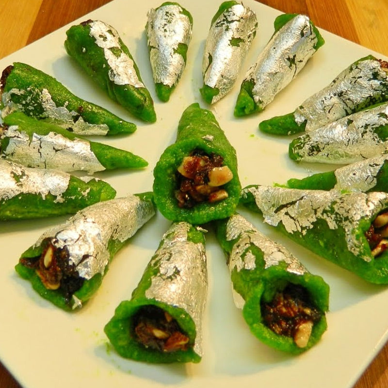 Handcrafted green Cashew Pan (Kaju Pan) sweets filled with dry fruits and topped with silver vark, by Athithi Gruha Foods.