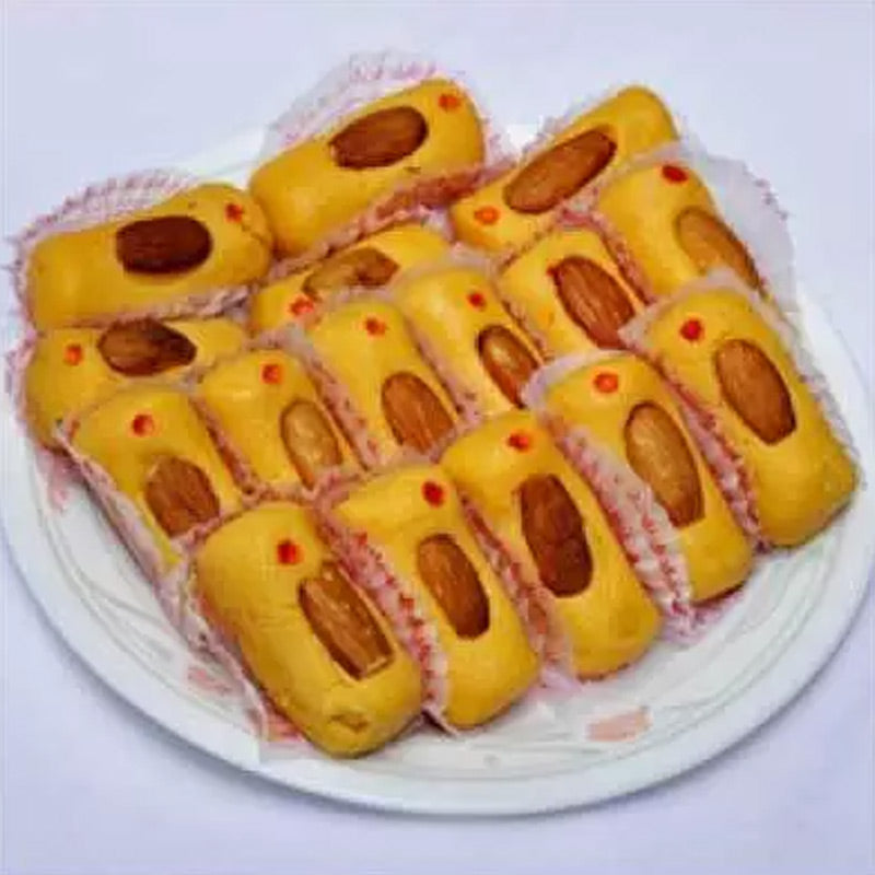 kova badam rolls milk sweet layered with crunchy almonds and creamy texture.